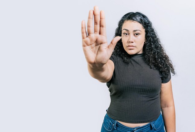 Ernstige vrouw afwijzen met de palm van de hand geïsoleerd Mensen gebaren stop geïsoleerd Latijnse vrouw gebaren stop met palm hand geïsoleerd