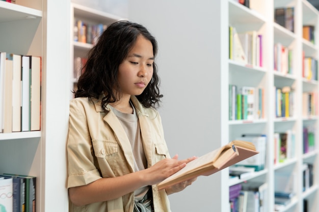 Ernstige vrouwelijke student met open boek leestekst