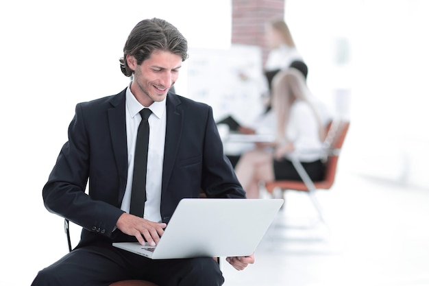 Ernstige zakenman die aan laptop in modern bureau werkt