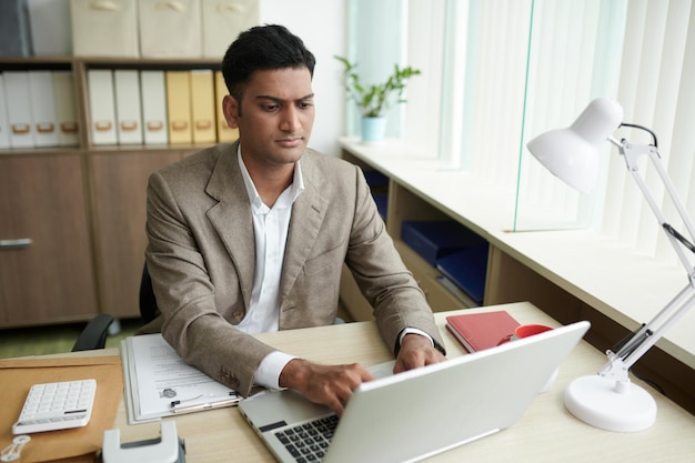 Ernstige zakenman die aan laptop werkt