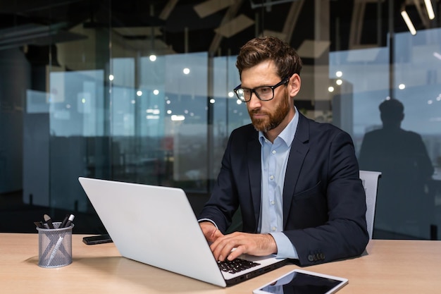 Ernstige zakenman werkt in kantoor op het werk volwassen baas in pak zittend op de computer