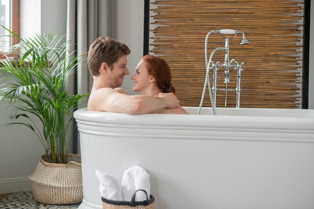 Erotic moments. A man and a woman having a bath together and looking excited