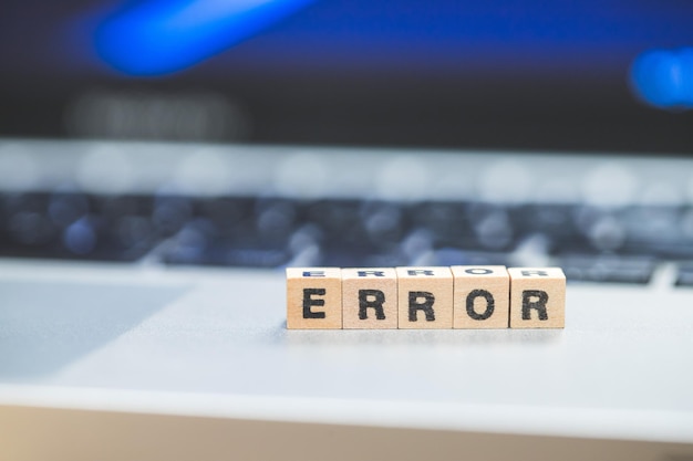 Photo error or bug concept wooden cubes with letters error lying on a laptop concept for computer crash