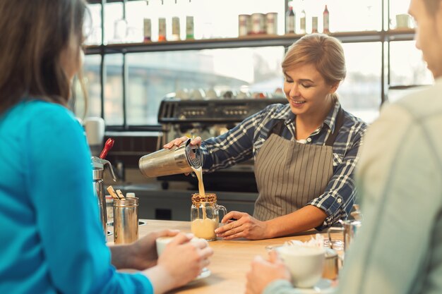 Ervaren barista in uniform laat zien hoe je koffie zet en geeft een masterclass. Kleine bedrijven, bezettingsmensen en serviceconcept, kopieer ruimte