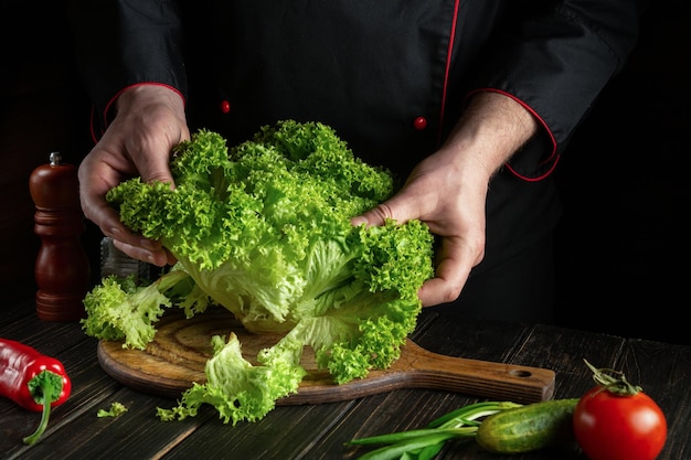 Ervaren chef-kok bereidt een salade in de keuken van het hotel Vegetarisch dieetmenu-idee