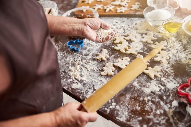 Ervaren kok met handvol meel en keukengerei