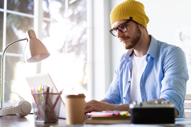 Ervaren mannelijke IT-professionele freelancer die aan het project van de klant werkt, met behulp van laptop en draadloos internet.