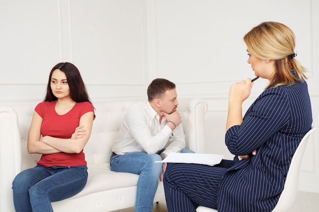 Ervaren psychiater die een paar raadpleegt. Man en meisje zitten op de bank afgewend van elkaar