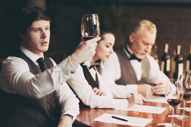 Ervaren sommelier kijkt naar sediment van wijn in glas.