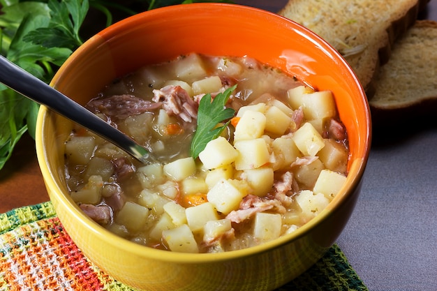 Erwtensoep met peterselie in een kom met croutons met knoflook