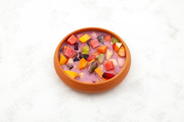 Фото es campur или sop buah в тарелке индонезийская еда, фруктовый коктейль, десерт или фруктовый суп с йогуртом