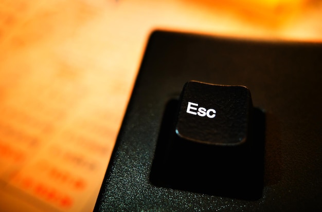 Клавиша Esc на фоне клавиатуры английского компьютера