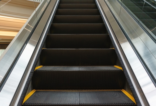 Escalator in community mall, shopping center. moving up\
staircase. electric escalator.