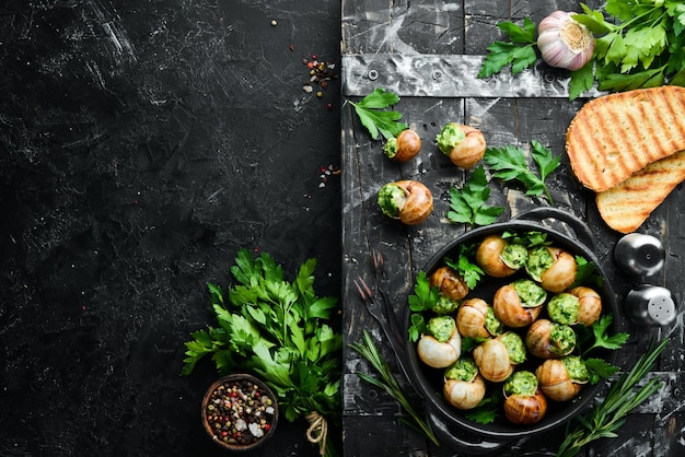 Escargots de Bourgogne 구운 달팽이와 마늘 버터와 바질 프랑스 전통 음식 상위 뷰 텍스트를 위한 여유 공간