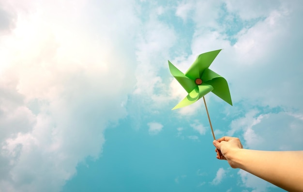 ESG and Clean Energy Concept Hand Raise up a Wind Turbine Paper into the Sky Decrease Carbon and Produce a Green Power World Earth Day Sustainable Resources Environmental Care