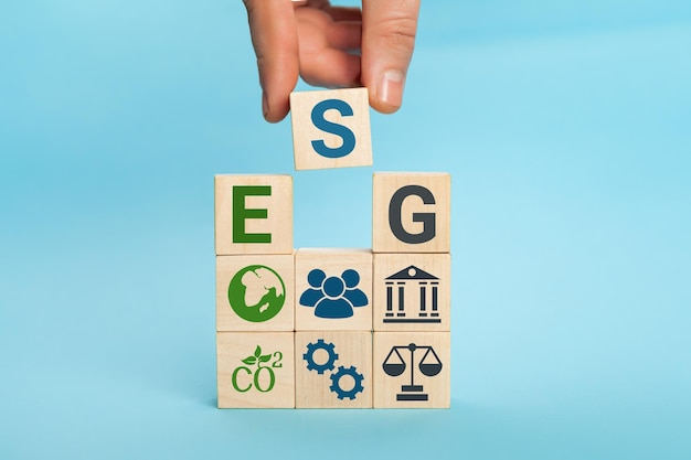 Esg-concept van ecologische, sociale en bestuurswoorden esg op een houten kubushand houdt houten kubus vast