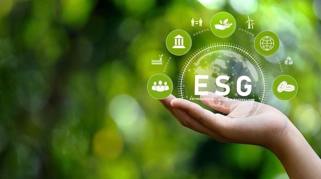 Photo esg icon concept in hand for environmental social and governance in sustainable renewable resources and networking icons on green background