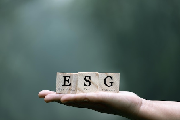 写真 esg (エコノミック・ソーシャル・アンド・ガバナンス・イン・サステイナブル・アンド・エイティカル・ビジネス) のアイコンを手にグリーン背景のネットワーク接続世界持続可能な環境コンセプト