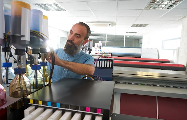 Foto espertise l'uomo nel plotter per l'industria della stampa di trasferimento