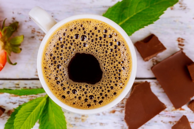 Caffè espresso con pezzi di schiuma, menta e cioccolatini