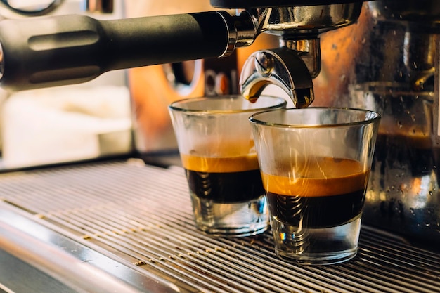 Photo espresso in glass below coffee maker at cafe