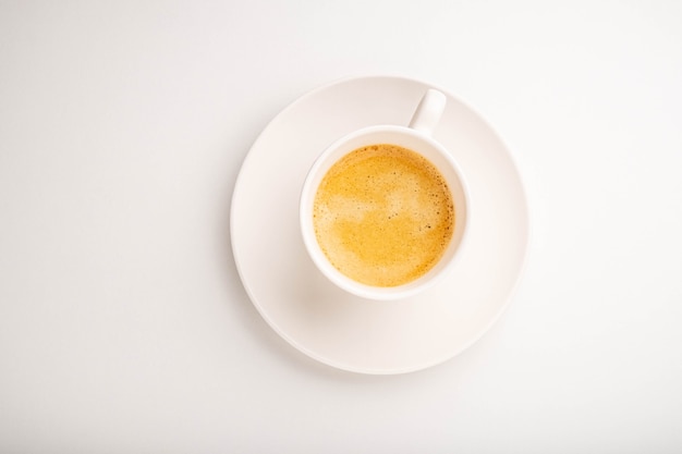 Espresso in een witte kop op een witte achtergrond. Uitzicht van boven