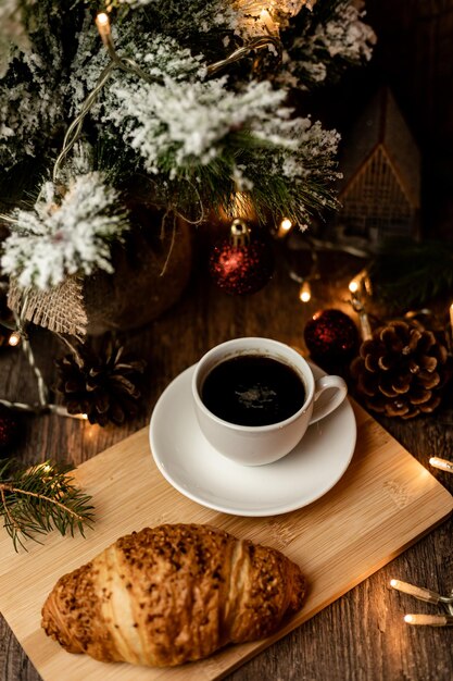 Espresso koffie croissant bij de kerstboom op tafel Koffiepauze