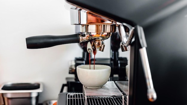 Photo espresso pouring from the coffee machine at the coffee shop