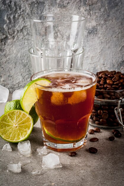 Espresso Tonic, refreshment summer drink with tonic water, lime and coffee, grey stone table, copy space