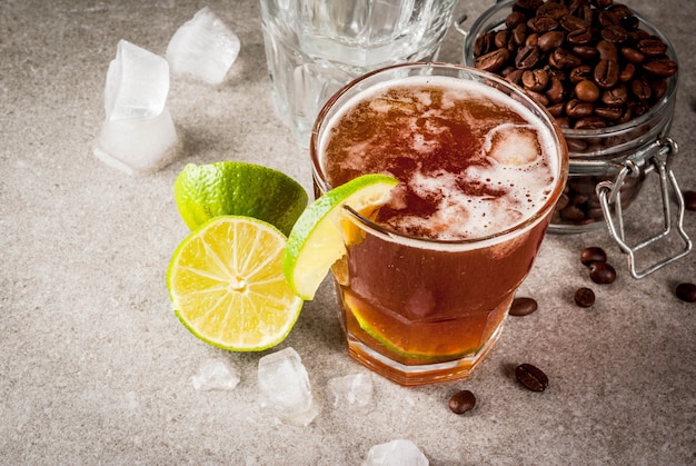 Espresso Tonic, verfrissing zomer drankje met tonic water, limoen en koffie, grijze stenen tafel, kopie ruimte