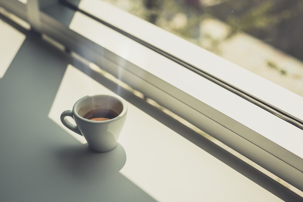 Espresso warme kop koffie op tafel bij het raam