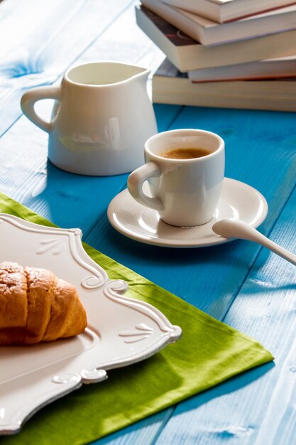 Foto espresso con croissant su tavola