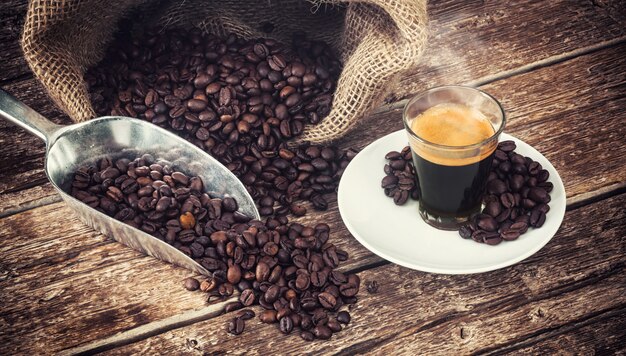 Foto espressokoffie in glaskop met koffiebonen.