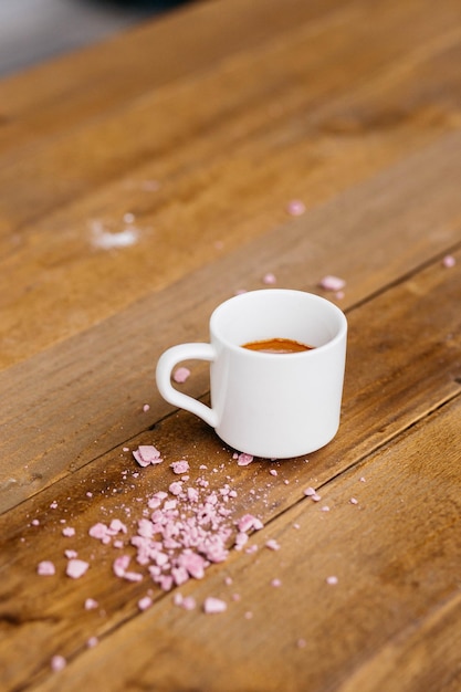 Espressokoffie op een houten tafel Koffie in een klein kopje Goedemorgen Koffie op tafel met roze kruimels