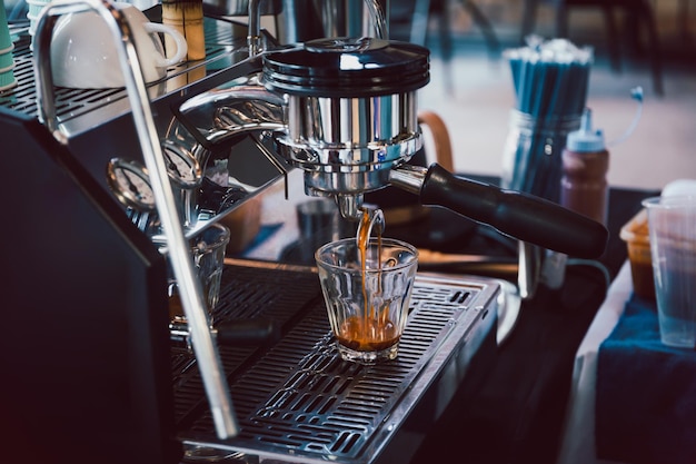 Espressomachine koffie gieten in glas in café