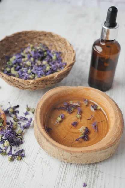 Essential lavender oil and flowers on table with copy space