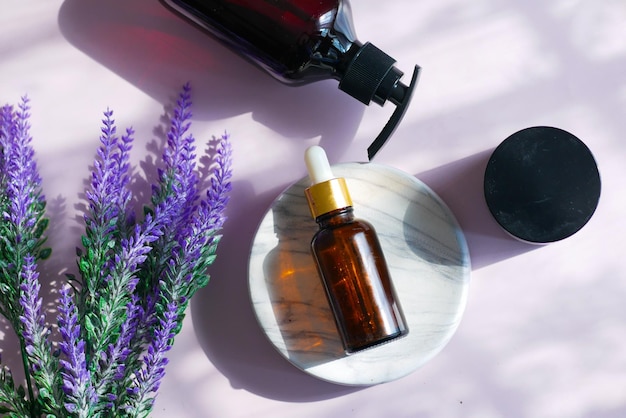 Essential lavender oil and flowers on table with copy space