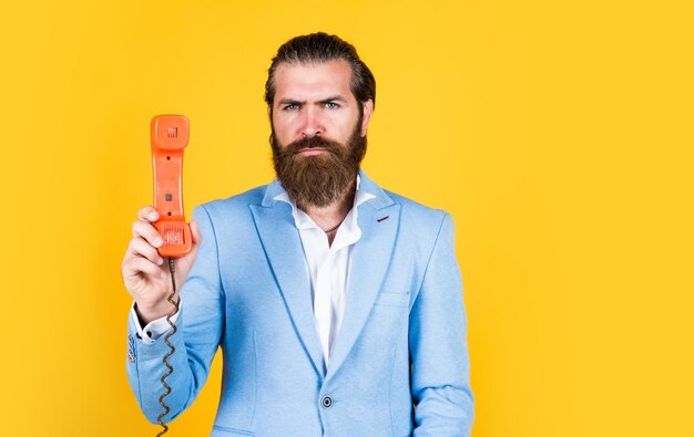 Essential to life man speak on phone serious man with retro phone brutal bearded man hold vintage telephone concept of technology in modern life communication idea of conversation