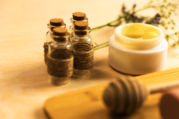 Essential oil bottle with skincare herbal cream on table