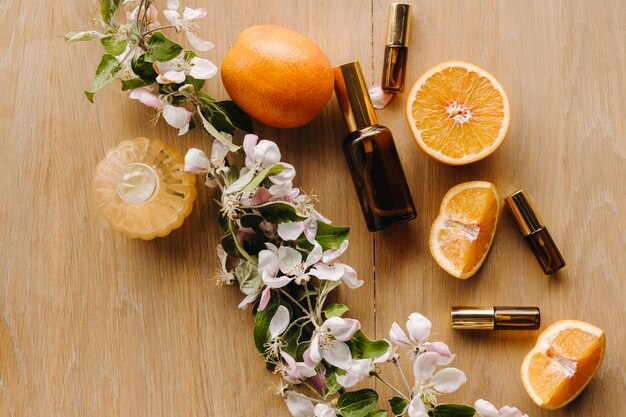 Essential oil in bottles with the aroma of apple and mint flowers lying on a wooden surface