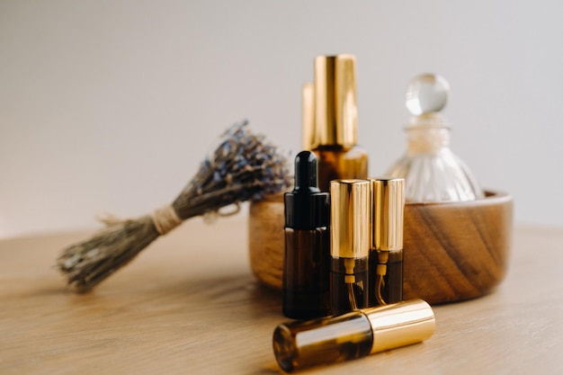 Essential oil in bottles with lavender fragrance lying on a wooden surface