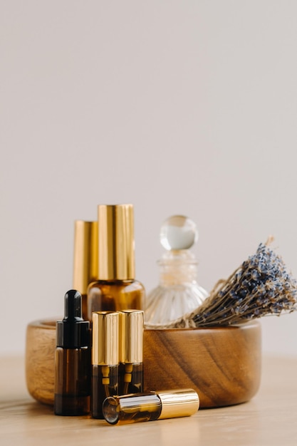 Essential oil in bottles with lavender fragrance lying on a wooden surface