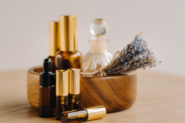 Essential oil in bottles with lavender fragrance lying on a wooden surface