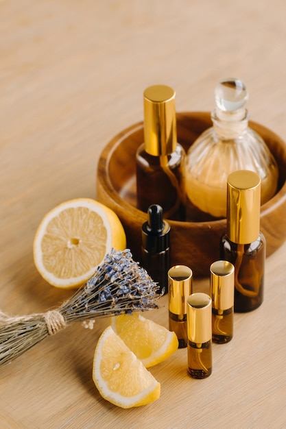 Essential oil in bottles with lemon and lavender fragrance lying on a wooden surface