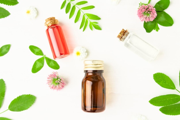 Olio essenziale ed estratti floreali su fondo di legno bianco prodotti cosmetici per aromaterapia