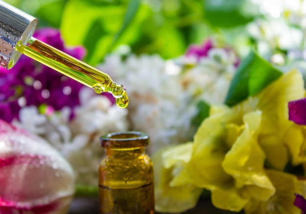 Essential oil of flowers drips into a jar selective focus