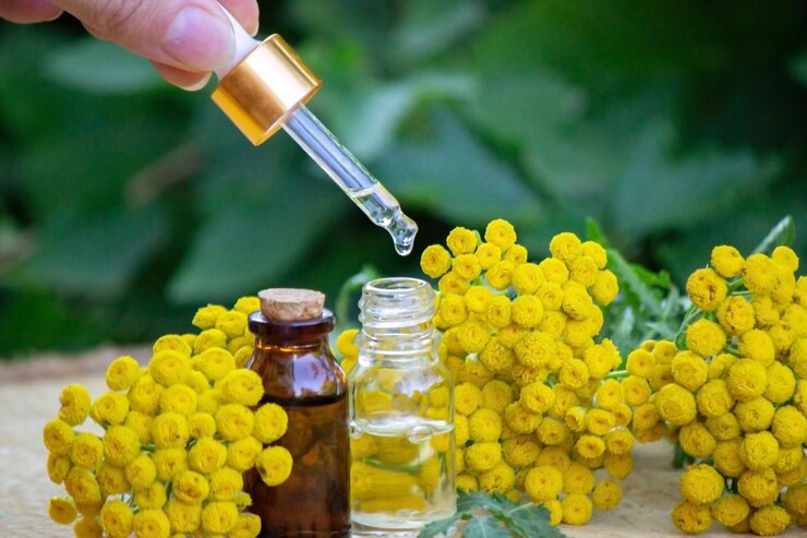 Photo essential oil of immortelle on a wooden background. selective focus. herbs