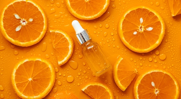 Photo essential oil of orange on a yellow background selective focus