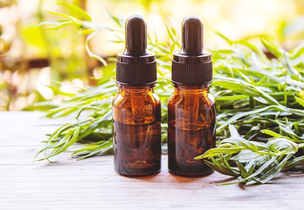 Essential oil of tarragon in a bottle. Selective focus. nature.