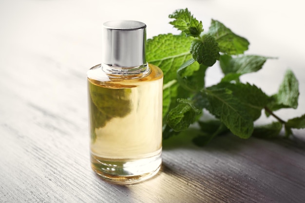 Essential oil with mint on wooden table